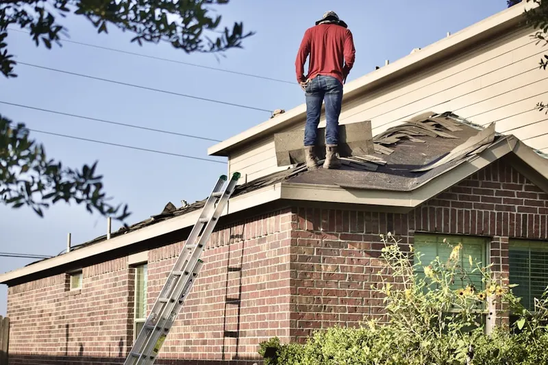 Professional roofer working on a residential roof in Ledyard